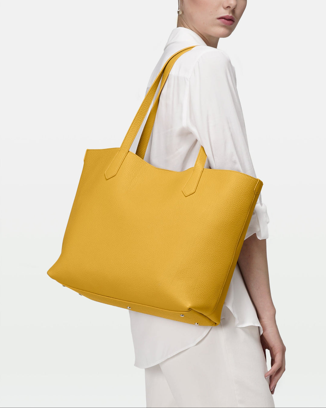 Woman carrying a yellow tote bag on a white background